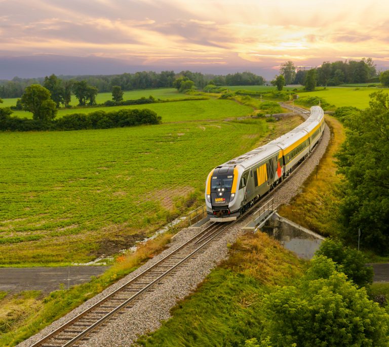 Train de VIA Rail traversant la campagne canadienne au coucher du soleil