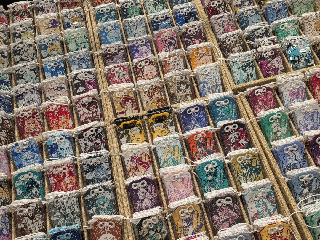 Présentoir d’amulettes japonaises omamori colorées illustrées de personnages d’anime à Otakuthon 2026.