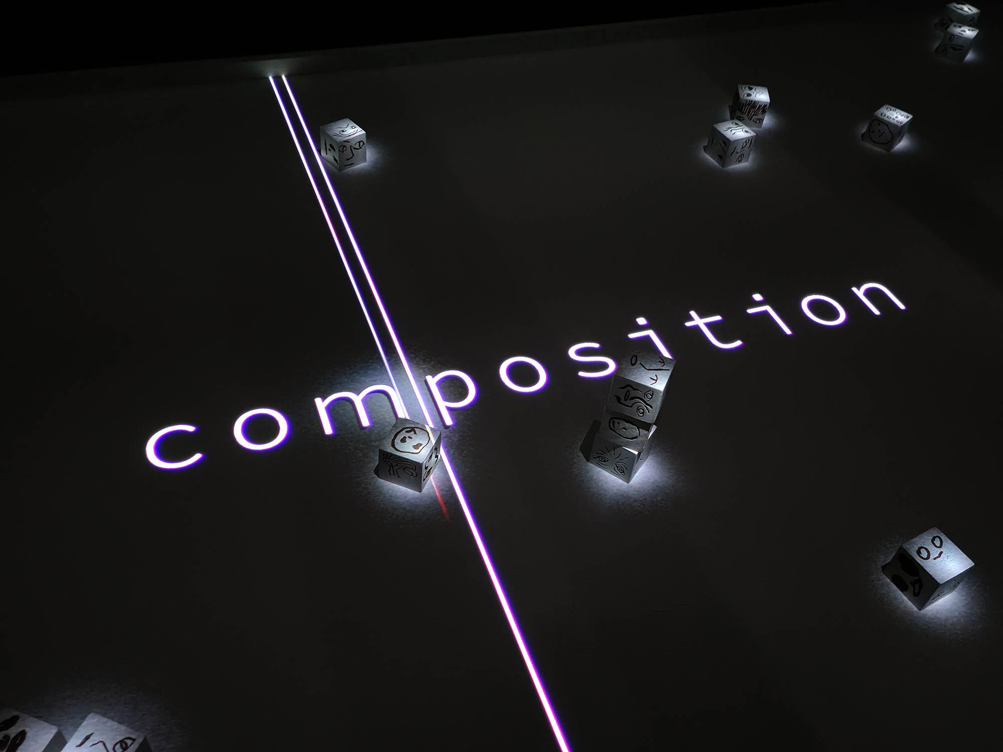 L’installation Composition avec ses cubes et son titre projeté.