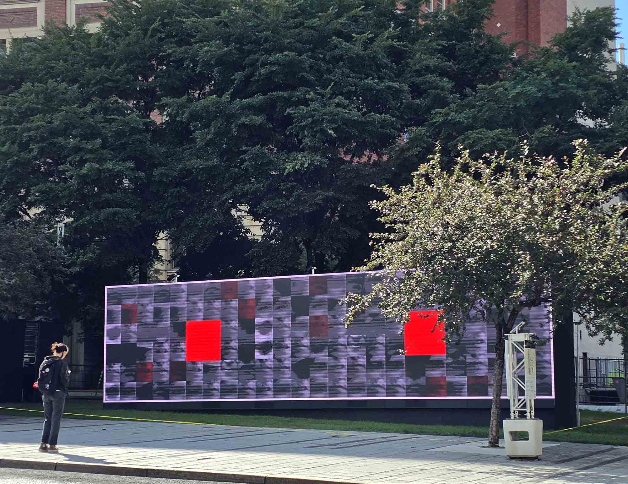 Une personne devant l’écran monumental de Twenty Twenty-Five à Montréal.