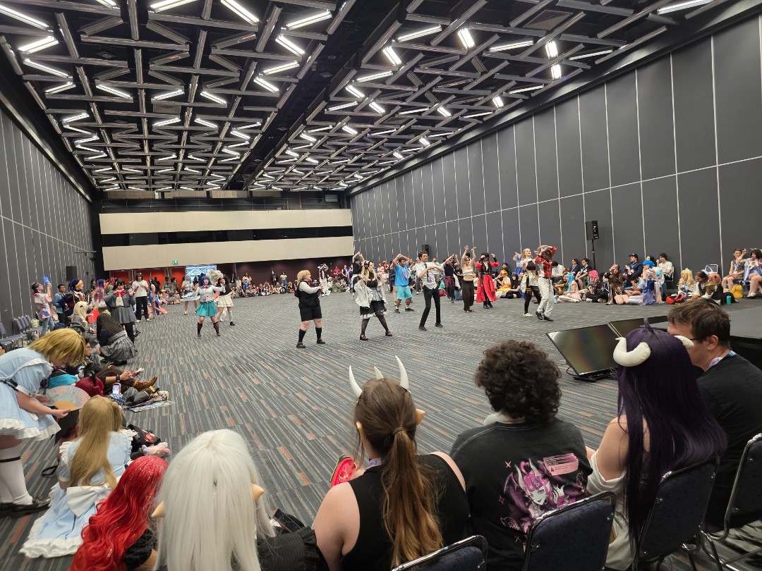 Des participants costumés dansent devant le public dans la salle de danse d’Otakuthon 2026 à Montréal.