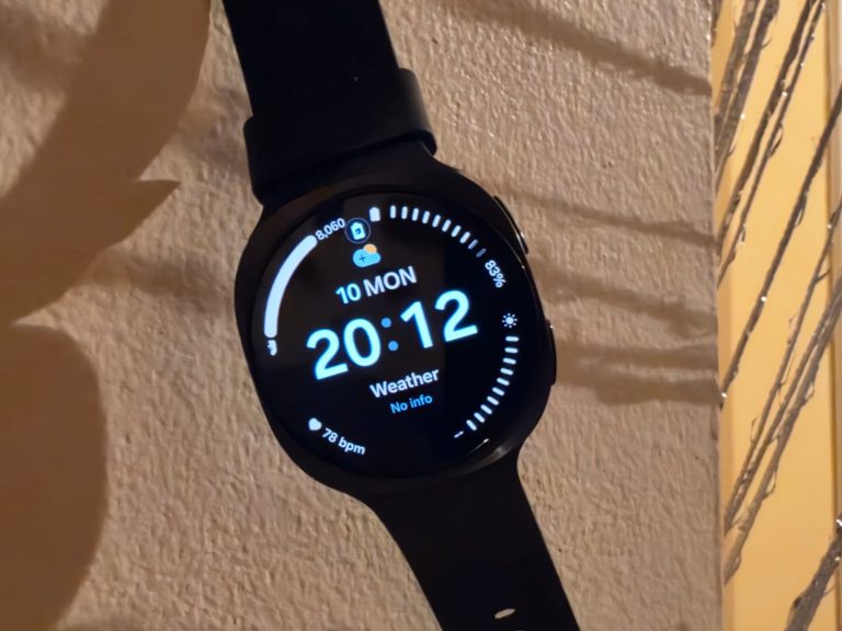 Galaxy Watch9 noire suspendue devant un mur avec des jeux d’ombre