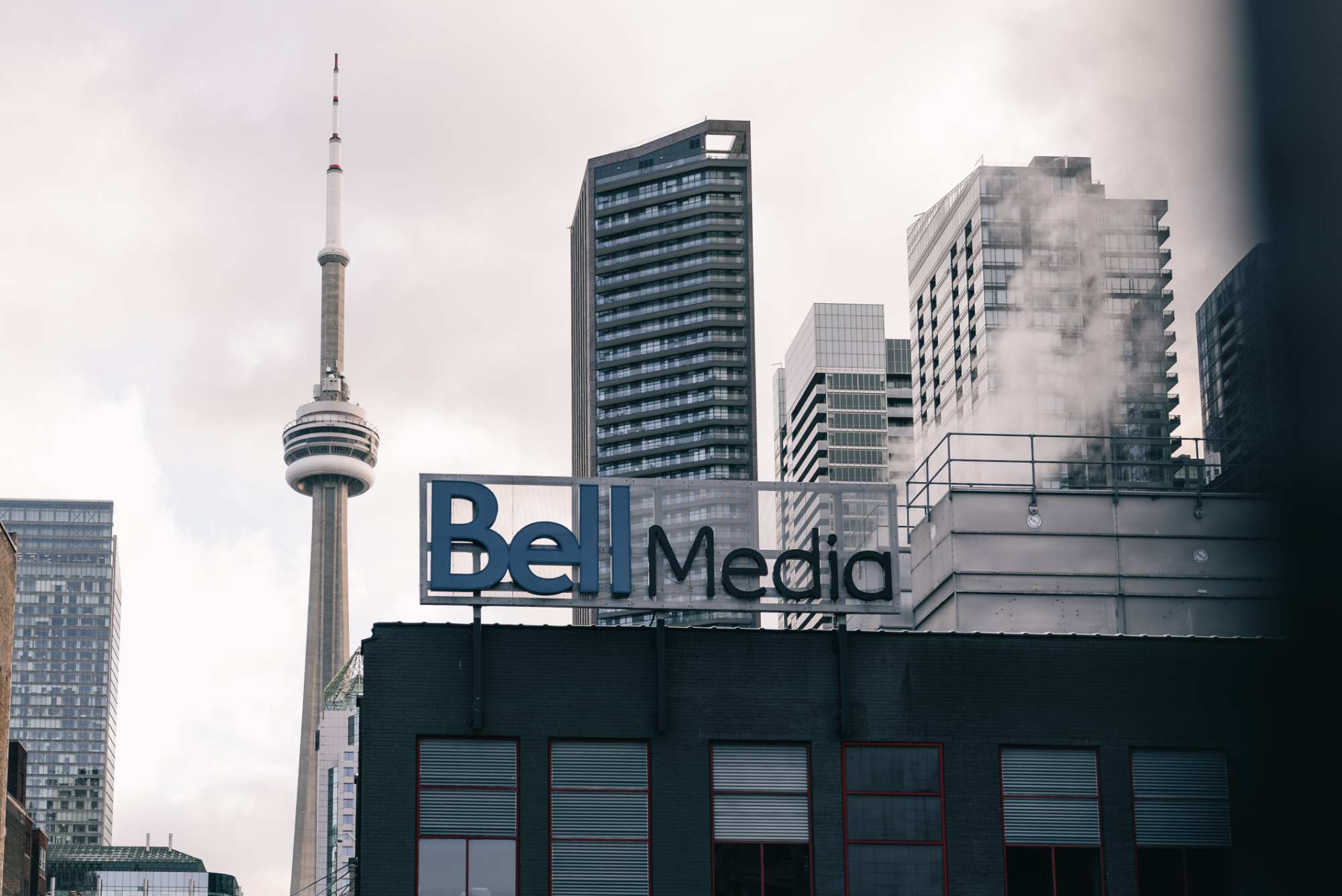 Enseigne Bell Media sur un bâtiment de Toronto avec la Tour CN et plusieurs gratte-ciel en arrière-plan.