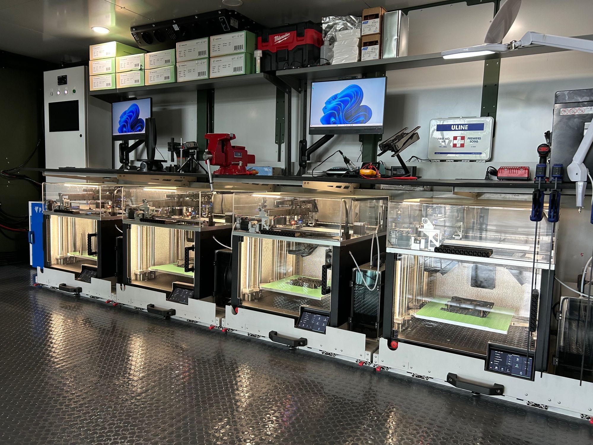 Rangée de quatre imprimantes 3D dans le module ForgeX de Sentinel