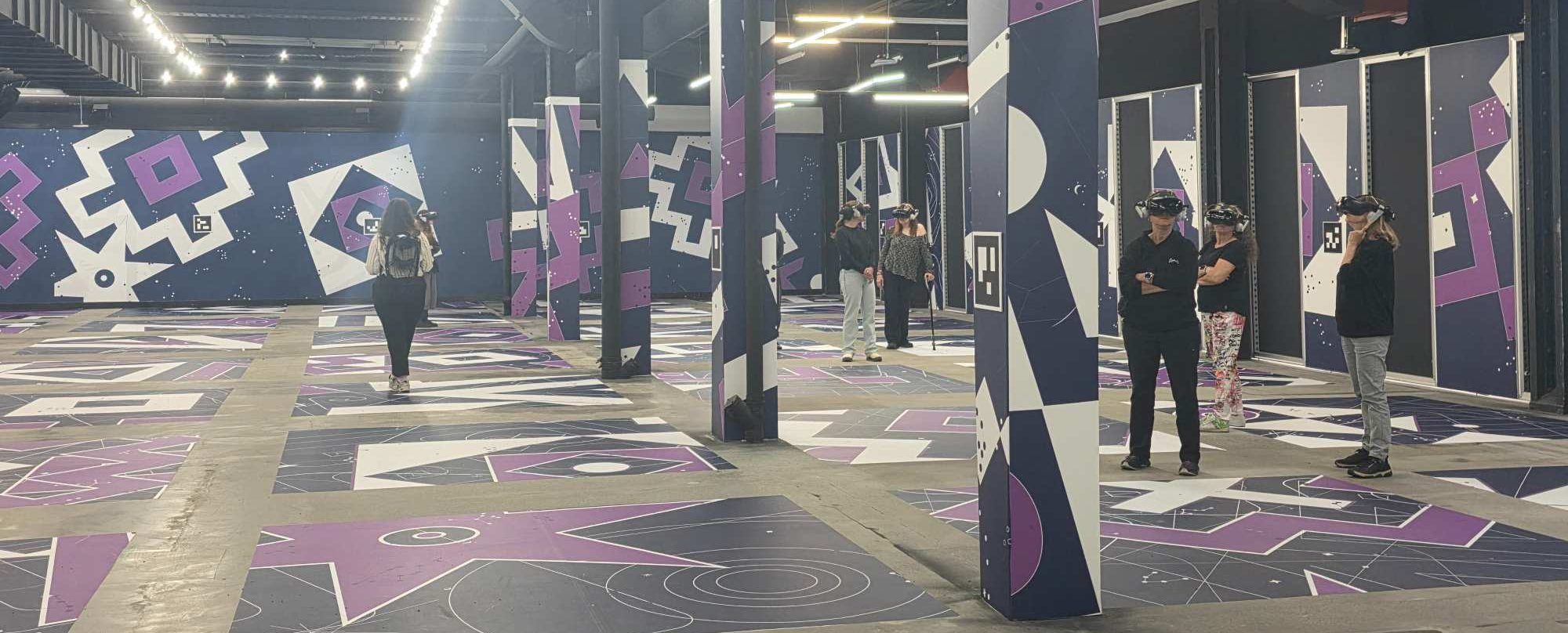 Des visiteurs équipés de casques de réalité virtuelle explorent la salle immersive d'Expériences Infinity à Montréal.