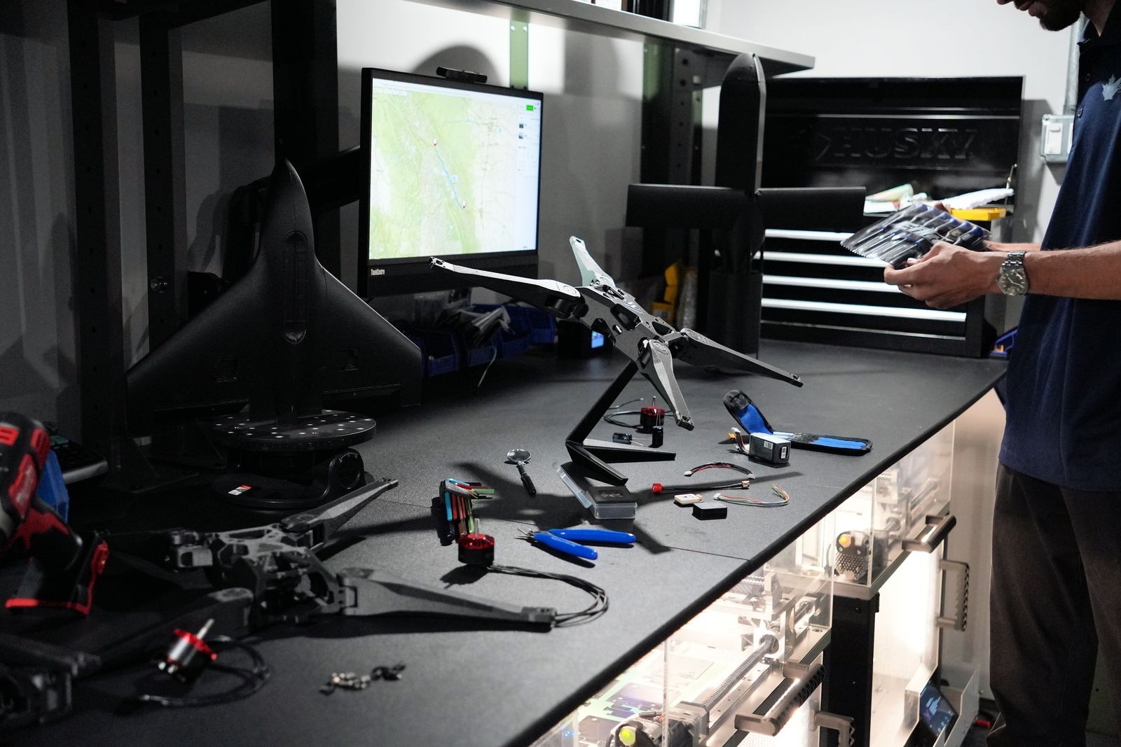 Technicien travaillant sur plusieurs drones et composants dans un atelier Sentinel